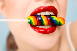 Young woman's mouth with lollipop. Focus on lips.